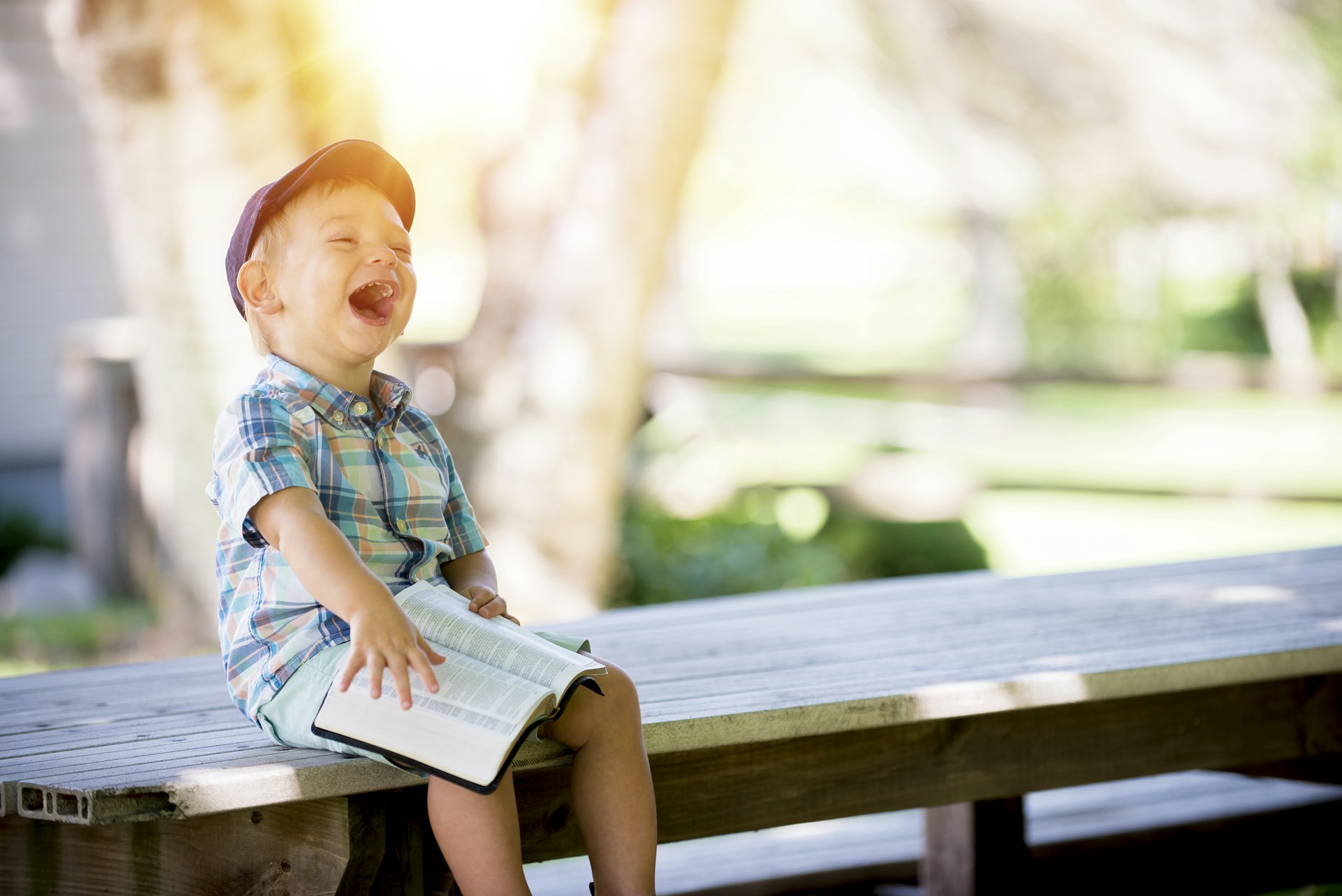 Child reading outdoors on a bench—quiet, everyday moment